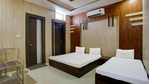 sypialnia z 2 łóżkami i drzwiami z oknem w obiekcie MAHADEV GUEST HOUSE w mieście Adźmer