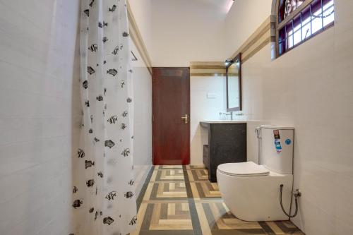 a bathroom with a toilet and a shower curtain at Villa Sunbreeze in Beruwala