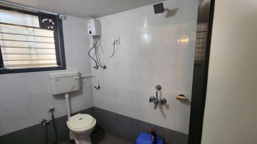 un piccolo bagno con servizi igienici e finestra di Anand Nivas a Malwan