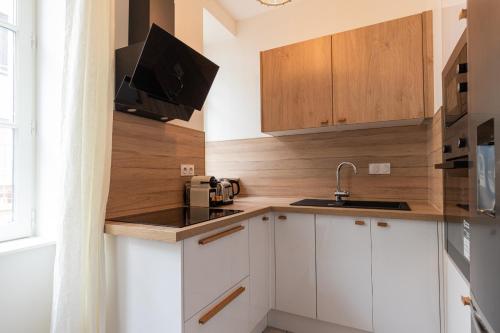 une petite cuisine avec des armoires blanches et un évier dans l'établissement DIFY Berthelot - Jean Mace, à Lyon