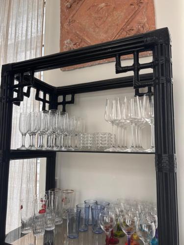 a shelf full of wine glasses on a wall at Maison Georges in Tourcoing