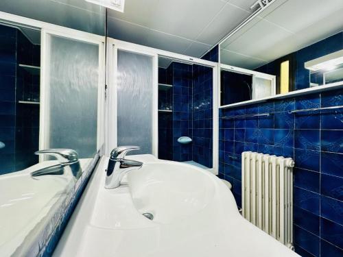 baño con 2 lavabos y una pared de azulejos azules en Apartament mar i vent, en Platja d'Aro