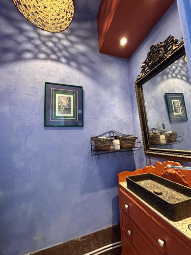 a blue bathroom with a mirror and a sink at Maison Georges in Tourcoing