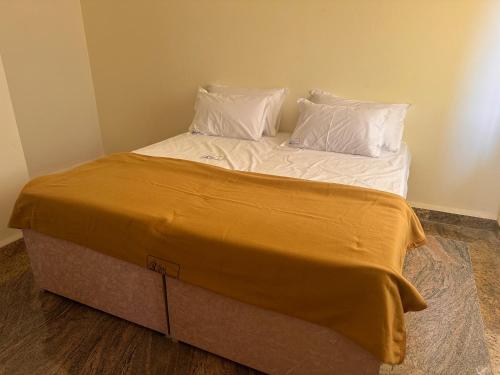 1 cama con 2 almohadas y caja en MPS Sai Palace, en Tiruvannāmalai