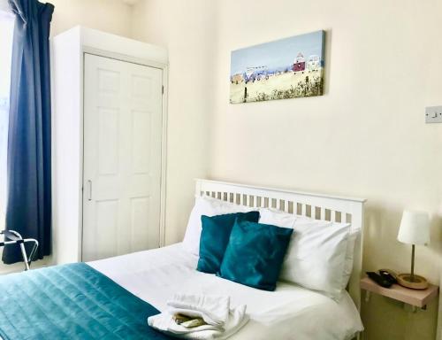 Un dormitorio con una cama con sábanas azules y blancas y una almohada azul. en Coastal Apartment, en Southend-on-Sea