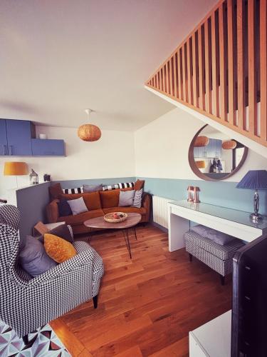 - un salon avec un canapé et une table dans l'établissement La petite maison bleue d'héricy, à Héricy