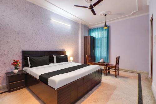 una camera con un grande letto e una sedia di Super OYO Dream Homes a Nuova Delhi