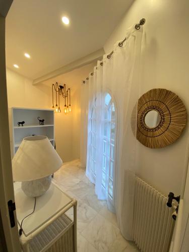 un couloir avec une table avec une lampe et une fenêtre dans l'établissement Villa face mer, à Royan