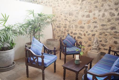 a group of chairs with blue pillows on a patio at Ratnakara in Dondra East
