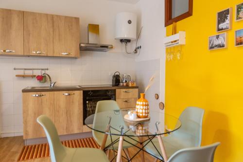 a kitchen with a glass table and green chairs at Casa Argo Guest House in Bisaccia