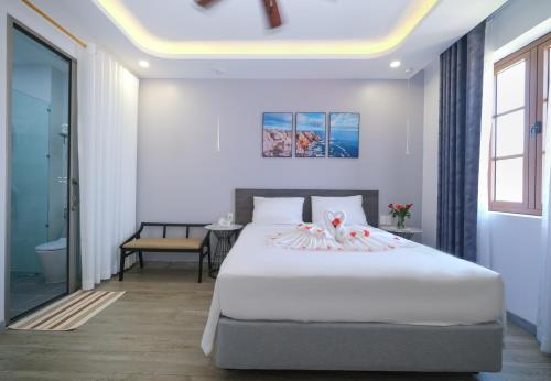 Un dormitorio con una gran cama blanca y una mesa en BELLA HOTEL PHU QUOC -Sunset Town, Địa Trung Hải- BIG PROMOTION 2024 en Phu Quoc