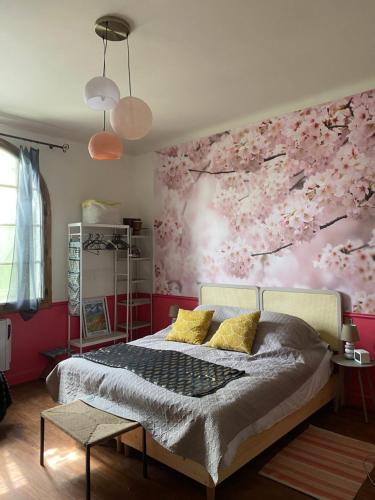 1 dormitorio con 1 cama con flores rosas en la pared en L Entre Deux chambres d hôtes, en Belin-Beliet