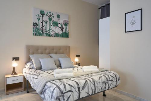 Bett in einem Schlafzimmer mit Wandgemälde in der Unterkunft Loft Tejares de Triana in Sevilla