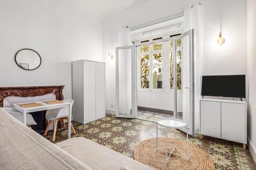 um quarto com uma cama, uma secretária e uma televisão em 4 - Centre historique - patio - clim em Perpignan