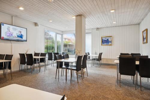 a dining room with tables and chairs and windows at BB-Hotel Frederikshavn Turisthotellet in Frederikshavn