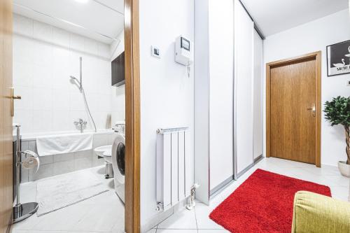 een badkamer met een rood tapijt naast een deur bij Story of swan lake in Zagreb