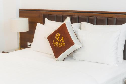 a book sitting on top of a bed with white pillows at Lam Anh Hotel 6 Ngoại Giao Đoàn BT4-10 in Hanoi