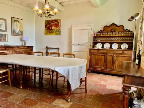 uma sala de jantar com uma mesa e uma mesa e cadeiras em MANOIR DE l'ARNAUDE em Fiac