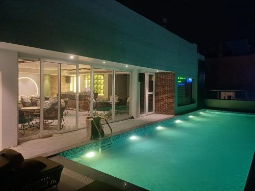 uma grande piscina com luzes numa casa em Regenta Place Amritsar by Royal Orchid Hotels Limited em Amritsar