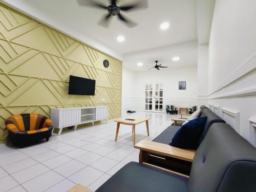 98 Homestay Sandakan في سانداكان: غرفة معيشة مع أريكة وتلفزيون