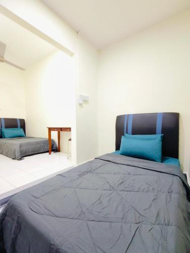 98 Homestay Sandakan في سانداكان: غرفة نوم بسرير كبير مع وسائد زرقاء