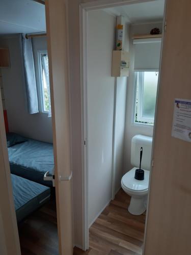 een kleine badkamer met een toilet en een bed bij camping le novela in Port-la-Nouvelle