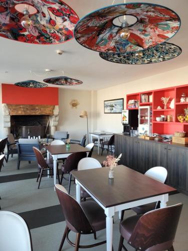 a restaurant with tables and chairs and a fireplace at Hôtel Port Haliguen in Quiberon