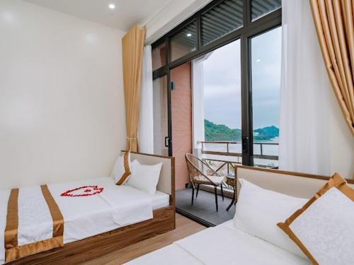 sypialnia z 2 łóżkami i balkonem w obiekcie Gia Cat Long Hotel w mieście Cát Bà
