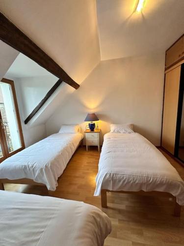 une chambre avec deux lits et une table avec une lampe dans l'établissement Happy House - 1h30 de Paris, à Batilly-en-Gâtinais