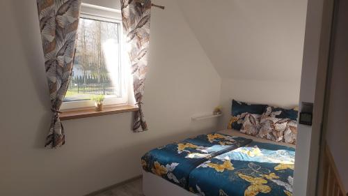 a small bedroom with a bed and a window at Spokojny zakątek in Ustroń