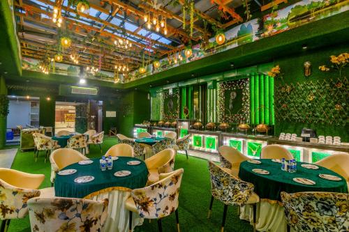 a restaurant with tables and chairs with green lighting at Shree Jee Hotel - NIT Faridabad in Faridabad