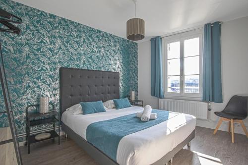 - une chambre avec un grand lit et du papier peint bleu et vert dans l'établissement A BABORD Fécamp, à Fécamp