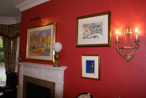 a living room with a red wall with a fireplace at Haley's Hotel in Leeds