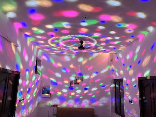um quarto com um tecto com luzes coloridas em Dreamy Residency em Pondicherry