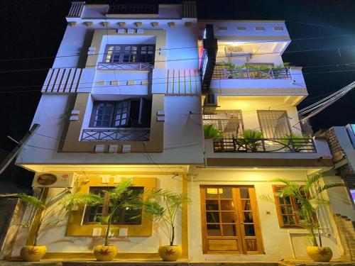 wysoki biały budynek z balkonem w nocy w obiekcie Dreamy Residency w mieście Puducherry