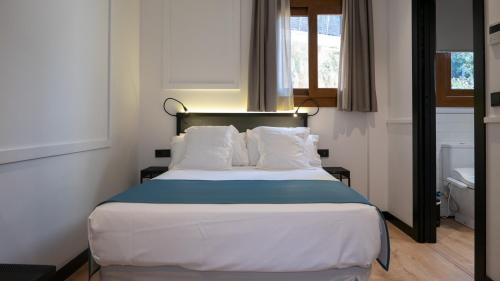 a bedroom with a large bed with white pillows at Hotel Boutique Puerta de las Granadas in Granada