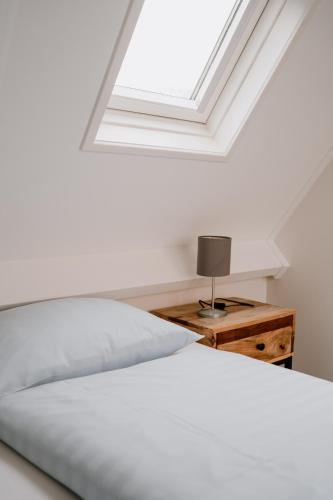 a bedroom with a bed and a skylight at Ons Kotje in Aagtekerke