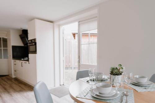 a white dining room with a table and chairs at Ons Kotje in Aagtekerke
