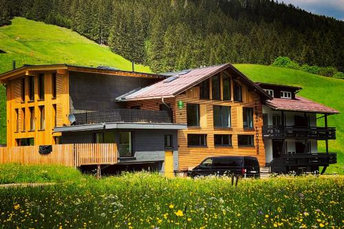 una casa con un coche aparcado delante en KWT Lodge, en Mittelberg