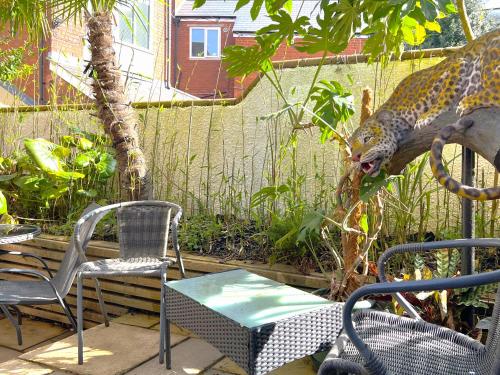 a patio with two chairs and a lizard behind a fence at Melbury Rooms & Studios in Exeter