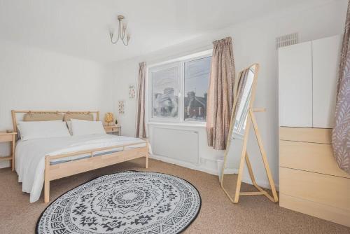 een slaapkamer met een bed, een raam en een tapijt bij 2 Bed in Historic Tonbridge - 35 mins from London in Tonbridge