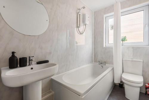 a white bathroom with a sink and a tub and a toilet at 2 Bed in Historic Tonbridge - 35 mins from London in Tonbridge