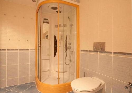 a bathroom with a shower with a toilet and a sink at Relax Vila se zahradním wellness in Ostrava