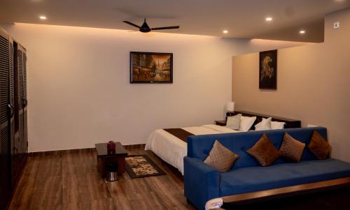 a bedroom with a bed and a blue couch at Oak House in Dimāpur