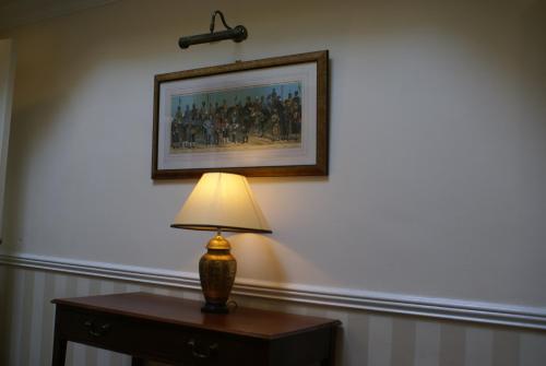 a lamp on a table with a picture on the wall at Haley's Hotel in Leeds