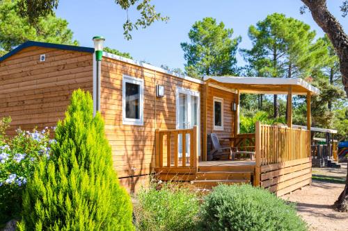 a tiny house with a porch and a gazebo at Campo Di Mare in Porto-Vecchio