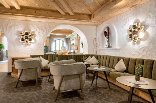 a living room with a couch and tables and chairs at Wellness & Relax Hotel Milderer Hof in Neustift im Stubaital