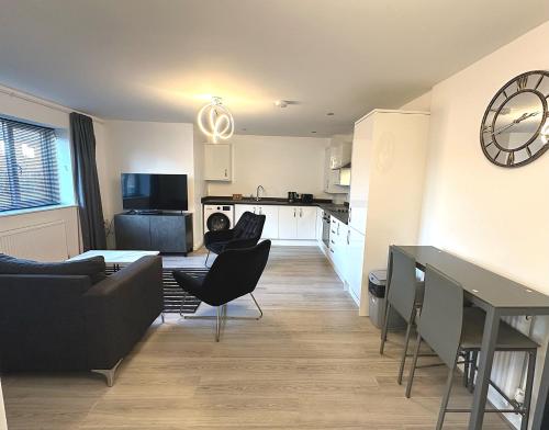 sala de estar y cocina con sofá y sillas en Apartment 1 - The Railway Apartment Building by Blue Skies Stays en Darlington
