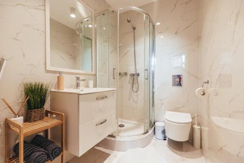 a bathroom with a shower and a toilet and a sink at Przytulny apartament przy dworcu in Radom