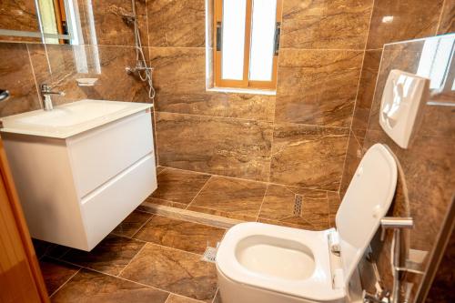 a bathroom with a toilet and a sink at Fabio Guest House in Gjirokastër